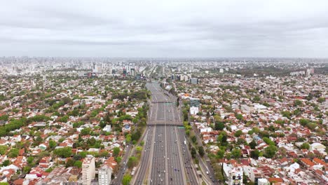 Drone-flying-backwards-revealing-the-view-from-above-and-far-away-from-the-large-Panamerican-South-American-highway-with-multiple-lanes-where-hundreds-of-vehicles-can-be-seen-crossing-it