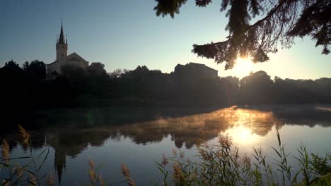 czech-city-Caslav-seen-over-a-steaming-pond-in-the-morning-sun,-static