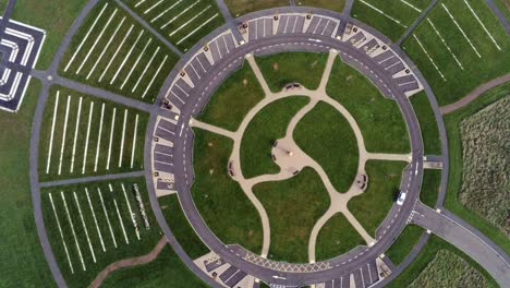 Vista-Aérea-Descendente-De-Diseño-Circular-Sobre-El-Jardín-Del-Cementerio-Paisajístico-Ornamental-Con-Estacionamiento-Alrededor-Del-Exterior