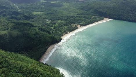 Aerial-top-down-shot-over-tropical-sandy-beach-with-blue-water-of-Bay-in-Caribbean-Sea-during-sunny-day-Playa-El-Valle,-Samaná---Beautiful-dense-lush-forest-landscape-with-palm-trees-and-plants