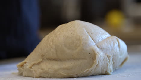 A-large-lump-of-dough-falling-from-a-mixing-bowl-to-the-table-for-kneading---slow-motion