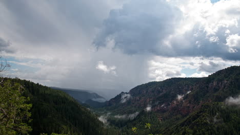 Storm-clouds-rolling-over-a-green-canyon-landscape--Time-lapse