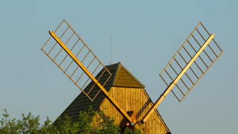 Blick-Auf-Eine-Historische-Holzmühle-Und-Ihre-Flügel,-Die-Zwischen-Den-Apfelbäumen-Stehen