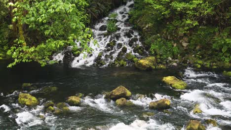 Water-Flowing-Into-Mossy-Rocks-In-The-River