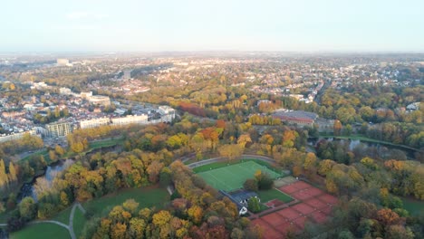 Skyline-of-residential-Brussels-with-tennis-courts-and-hockey-pitch-on-top-of-the-Woluwe-park---Aerial-view