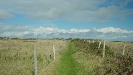 4k-Landschaftsaufnahme-Eines-Fußwegs-Zwischen-Feldern-Auf-Der-Insel-Portland-In-Dorset,-England,-An-Einem-Schönen-Sonnigen-Tag