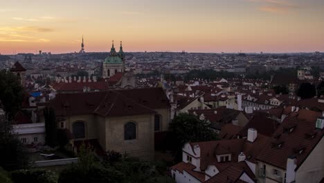 Sunrise-timelapse-over-the-roofs-of-Mala-Strana-in-Prague,-Czech-Republic-as-seen-from-Hradcany-near-Prague-Castle-as-the-sun-slowly-illuminates-the-famous-red-roofs