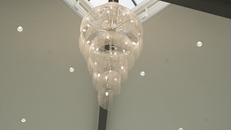 Panoramic-view-of-a-spiral-chandelier-on-a-tall-event-venue-ceiling
