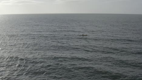 Ein-Einsamer-Seekajakfahrer-Paddelt-über-Die-Leere-Weite-Des-Stahlblauen-Ozeans