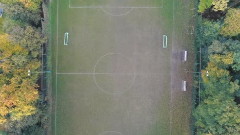Top-down-drone-flying-away-from-circle-of-football-field