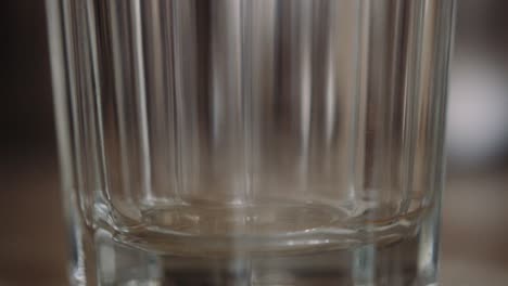 Instant-powdered-coffee-scooped-into-transparent-glass,-shallow-focus-close-up,-slowmo