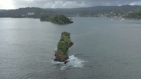 Aerial-orbiting-around-sea-rocks-with-Samana-Bay-in-background,-Dominican-Republic