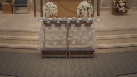 Decorated-wooden-bench-for-bride-and-groom-at-their-Catholic-church-wedding