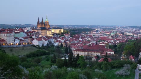 Day-to-night-timelapse-in-Prague,-Czech-Republic-as-seen-from-Strahov-gardens-with-view-of-Prague-Castle-lighting-up,-Malá-strana-and-downtown-in-the-distance