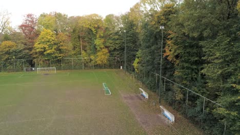 Leere-Fußballbänke-Auf-Dem-Verlassenen-Fußballplatz---Rotierender-Drohnenschuss