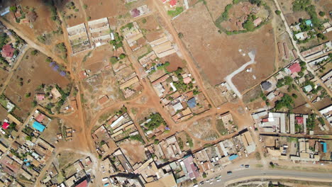 Top-down-aerial-of-edge-of-town-near-rural-farmlands-in-Kenya