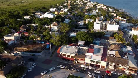 Drone-Panning-Shot-of-a-Beach-Town-in-the-Mexican-Caribbean-at-Sunset