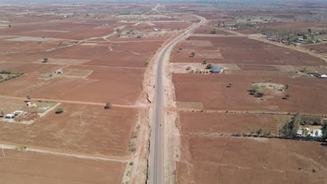 Vista-De-ángulo-Alto-Del-Tráfico-Distante-Conduciendo-Por-Una-Sola-Carretera-En-Las-Zonas-Rurales-De-Kenia