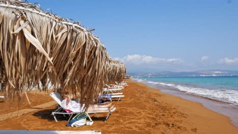 Tourists-Relaxing-On-The-Red-Sand-Shore-Of-Megas-Lakkos-Beach-At-Daytime,-Cephalonia-Island,-Greece,-Europe---static-shot