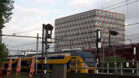 Züge-Auf-Der-Eisenbahn-Mit-Rathaus-Von-Gouda-In-Den-Niederlanden-Im-Hintergrund