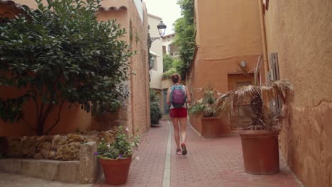 A-female-tourist-walking-past-a-peaceful-locality-in-Begur-famous-for-its-historical-past