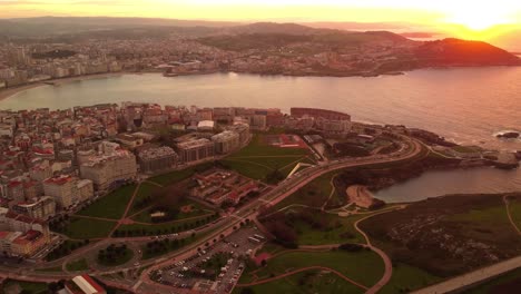 Luftbild-Bei-Sonnenuntergang-Der-Region-La-Coruna-Galizien-Drohne-Fliegt-über-Das-Stadtzentrum-Und-Den-Küstenstrand-Und-Enthüllt-Das-Stadtbild