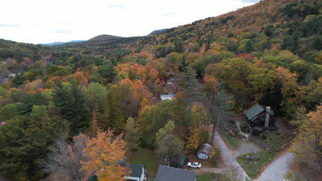 Aerial-View-of-Houses-in-Colorful-Forest-on-Autumn-Day-in-Landscape-of-Newbury,-Lake-Sunapee-Area,-Drone-Shot