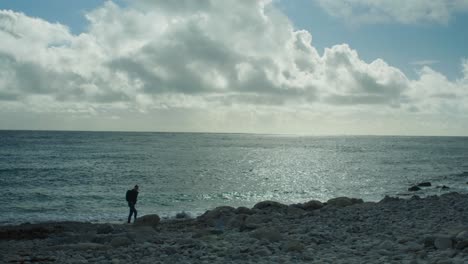 Panorama-Landschaftsaufnahme-In-Zeitlupe-4k-Eines-Mannes,-Der-An-Einem-Sonnigen-Tag-Am-Felsigen-Strand-Von-Church-Ope-Auf-Der-Insel-Portland-In-Dorset,-England,-Spazieren-Geht