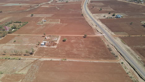 Aerial-of-car-leaving-main-road-onto-a-dirt-road-in-a-dry-and-arid-landscape