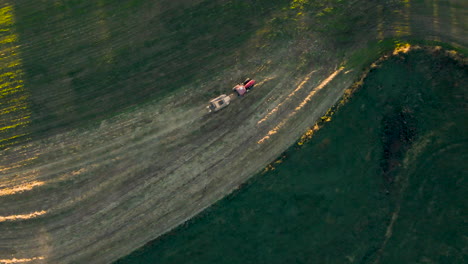 Top-Down-Aerial-Of-Tractor-Pulling-Baling-Machine-In-Late-Afternoon-Light-In-Rural-Pennsylvania,-U