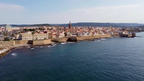 Revealing-drone-clip-over-the-scenic-town-of-Alghero-in-Sardinia,-Italy-with-the-old-town-and-the-local-cathedral