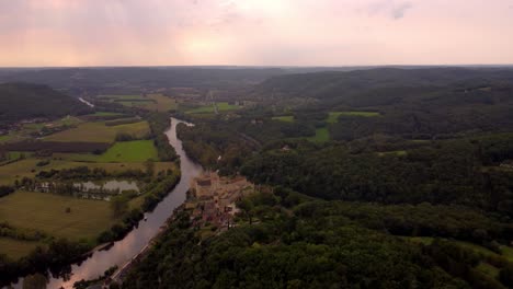 Aerial-view-of-Beynac-et-cazenac-france-medieval-small-stone-village-in-the-dordogne-forest-historical-site-at-sunset