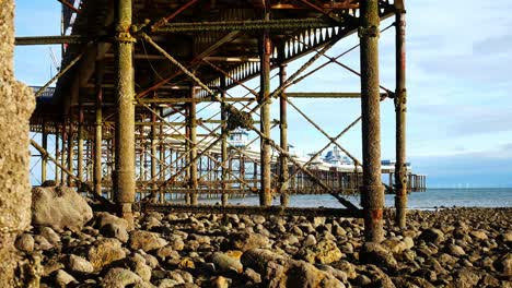 Under-weathered-worn-Llandudno-pier-landmark-support-pillars-at-low-tide
