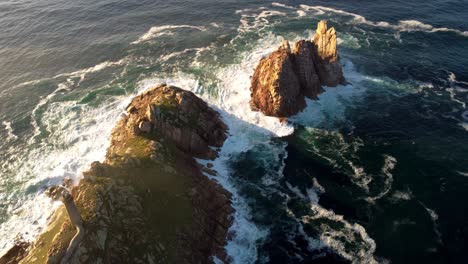 Aerial-drone-view-of-Galicia-Spain-coastline-lighthouse-rock-bound-cliff-formation-natural-sunset-landscape