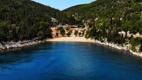 Foki-Beach-With-Small-Tavern,-Lush-Green-Forest-And-Rocky-Outcrops-In-Kefalonia,-Greece
