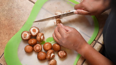 Slicing-mushrooms-to-add-to-a-favorite-recipe---top-down-or-overhead-view-in-slow-motion