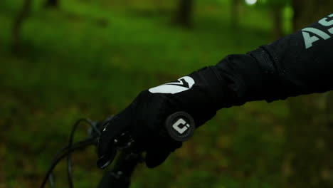 Close-up-view-of-mountain-bike-handlebars-and-detail-on-rider's-hand