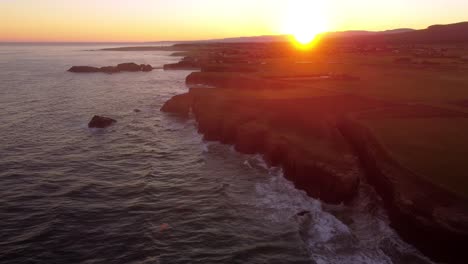 Luftaufnahme-Des-Sonnenuntergangs-Der-Felsengebundenen-Ozeanklippenformation-In-Der-Region-Galizien-Nördlich-Von-Spanien-Praia-Das-Catedrais-Befindet-Sich-An-Der-Nordwestküste