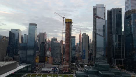 Aerial-view-of-high-rise-in-Hudson-Yards,-cloudy-dusk-sky-in-Manhattan,-New-York---pan,-drone-shot