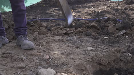 Unrecognizable-man-with-shovel-digging-hole