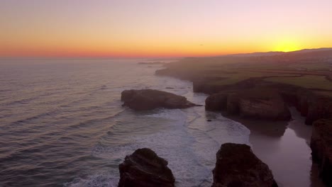 Aerial-view-Praia-das-Catedrais-is-on-the-northwest-coast-of-Spain-sunset-drone-footage-in-tourist-holiday-destination