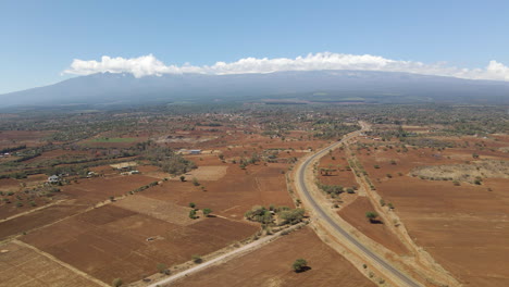 Muñeca-Aérea-De-Un-Hermoso-Paisaje-En-La-Zona-Rural-De-Kenia-Con-Un-Solo-Camino-Que-Atraviesa-El-Campo