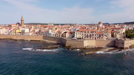 Orbiting-clip-around-the-medieval-castle-walls-over-the-ocean-in-the-town-of-Alghero,-Sardinia,-Italy