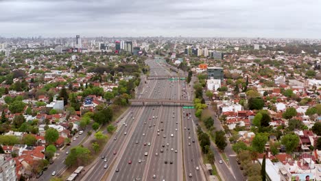 Panamerikanische-Große-Autobahn-Mit-Mehreren-Spuren-Und-Fahrzeugen,-Die-Entlang-Einer-Großstadt-Von-Buenos-Aires-Mit-Vielen-Hohen-Gebäuden-Kreuzen