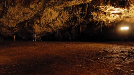 Cueva-De-Drogarati-En-La-Isla-De-Cefalonia-Iluminada-En-Naranja,-Grecia---Toma-Panorámica