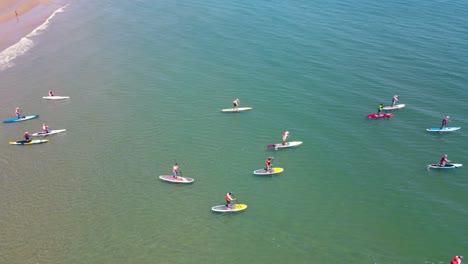 Standup-paddleboarders-at-racing-event-on-waters-of-Rexhame-beach,-Marshfield