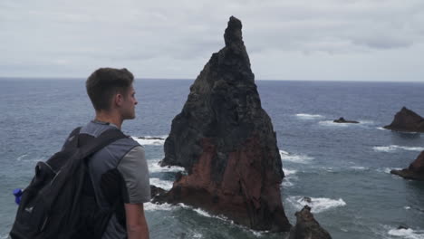 Man-stands-in-front-of-famous-rock-formation-at-Ponta-de-Sao-Lourenco