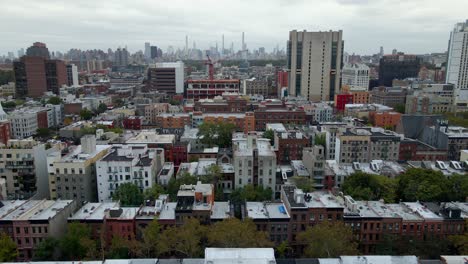 Aerial-drone-view-over-apartments-in-Harlem-towards-Midtown-Manhattan,-in-cloudy-NYC