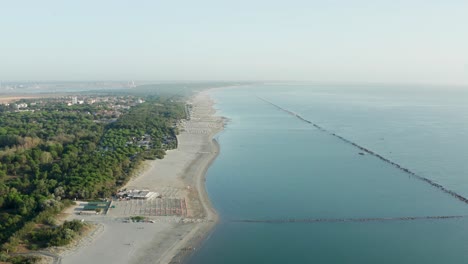 Aerial-view-of-sandy-beach-with-umbrellas,gazebos-and-town