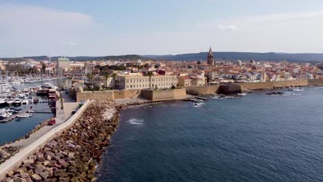 Langsamer-Filmischer-Drohnenclip-Der-Altstadt-Von-Alghero-In-Sardinien,-Italien-Mit-Einem-Großen-Jachthafen-Und-Luxuriösen-Yachten-Im-Vordergrund